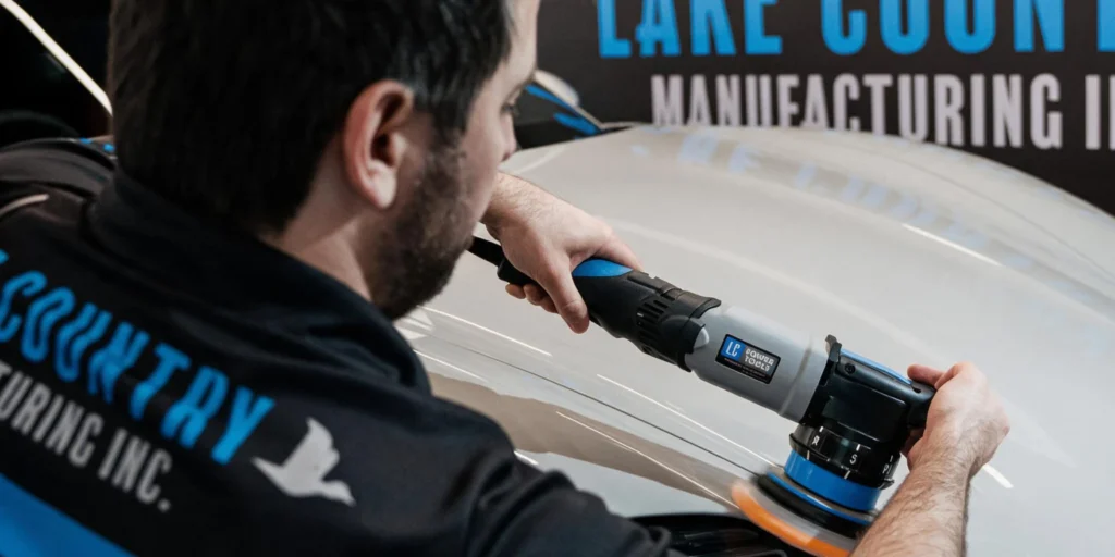 Technician using a Lake Country polisher to improve the surface of a vehicle