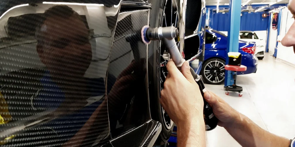 Detailer perfecting the gloss on a black vehicle